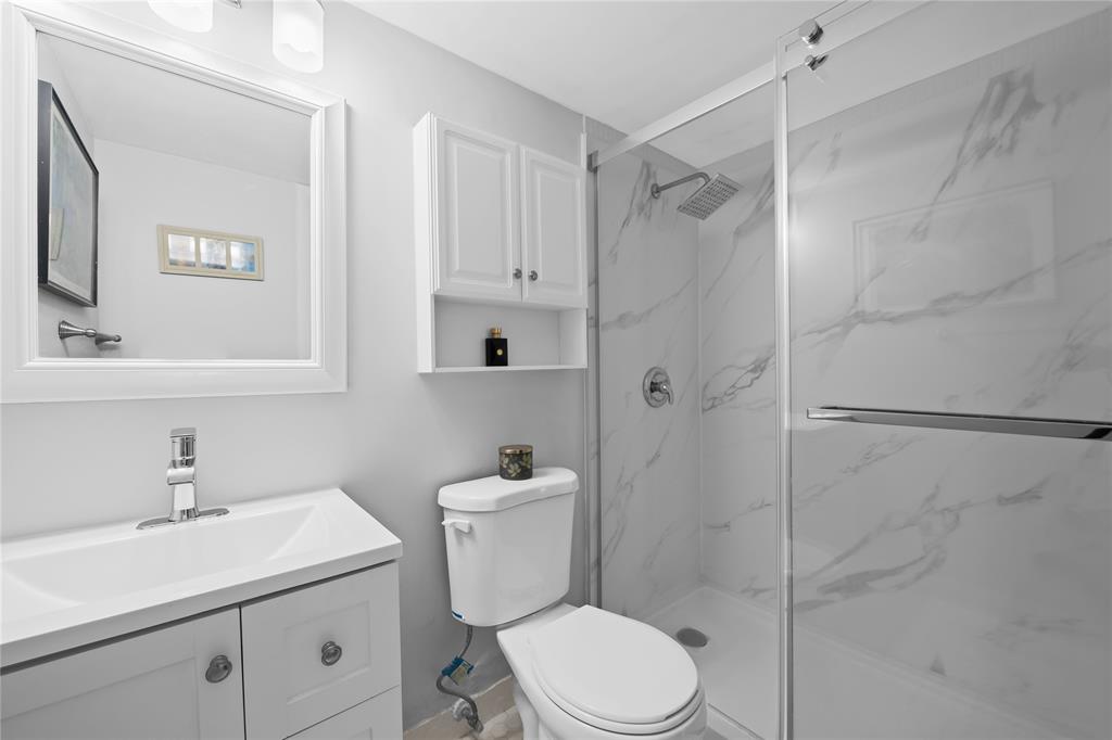 318 Oakridge R, Unit 318 Deerfield Beach, FL 33442 - Photo 17 of 26 a white toilet sitting next to a bathroom sink
