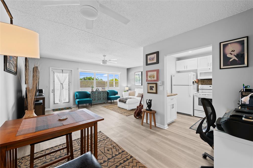 318 Oakridge R, Unit 318 Deerfield Beach, FL 33442 - Photo 4 of 26 a living room with furniture a flat screen tv and a table