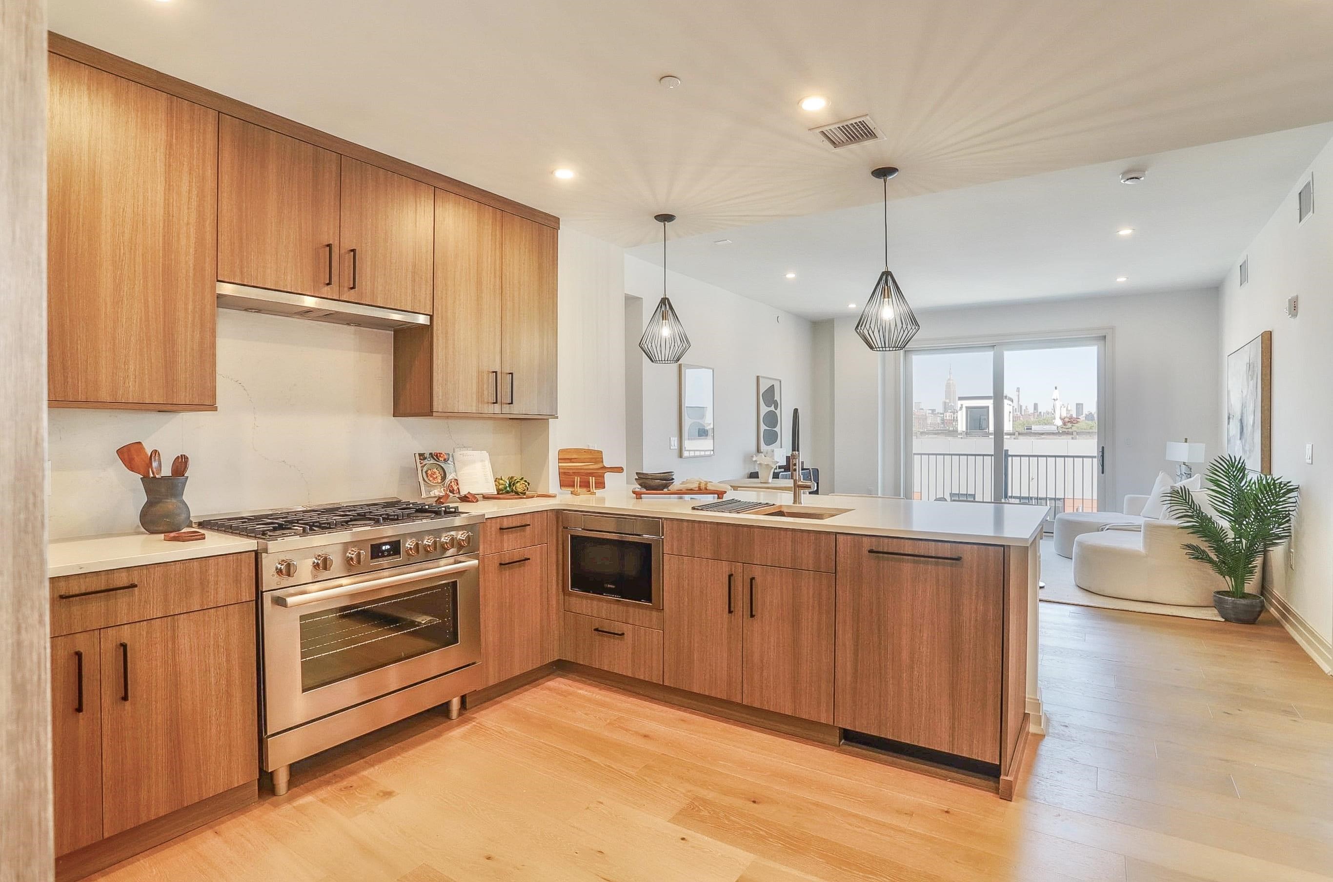 a large kitchen with stainless steel appliances granite countertop a stove a sink dishwasher and a refrigerator with wooden floor
