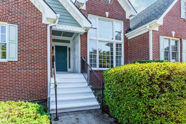 a front view of a house with a yard and potted plants
