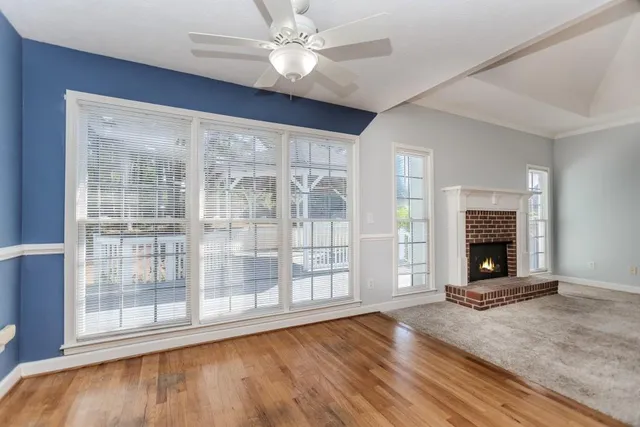 a view of an empty room with a chandelier fan