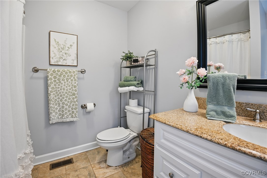 14609 Gatewood Road Dewitt, VA 23840 - Photo 13 of 25 Bathroom with baseboards, toilet, vanity, and ston