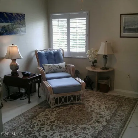 a living room with furniture a rug and a lamp