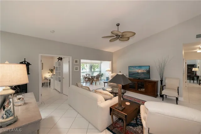 a living room with furniture a ceiling fan and a flat screen tv
