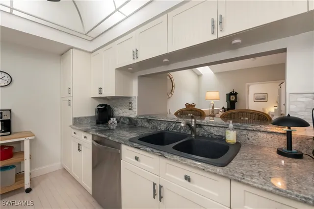a kitchen with stainless steel appliances granite countertop a sink a stove and cabinets