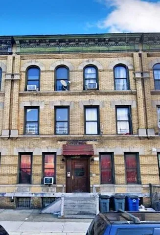 a view of building with lot of windows and refrigerator