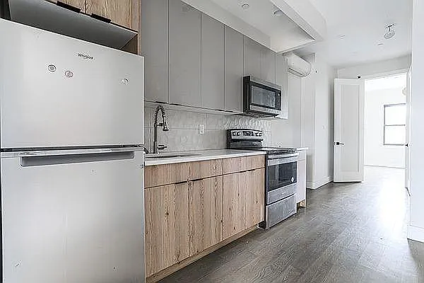 a kitchen with stainless steel appliances a refrigerator and a stove top oven