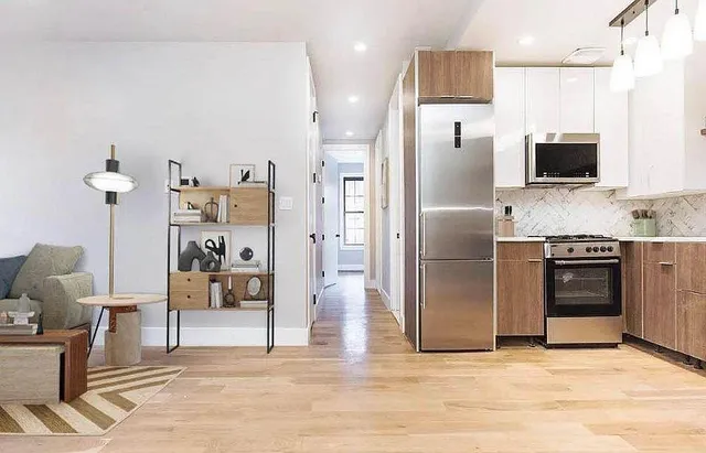 a kitchen with stainless steel appliances kitchen island granite countertop a refrigerator and a stove top oven