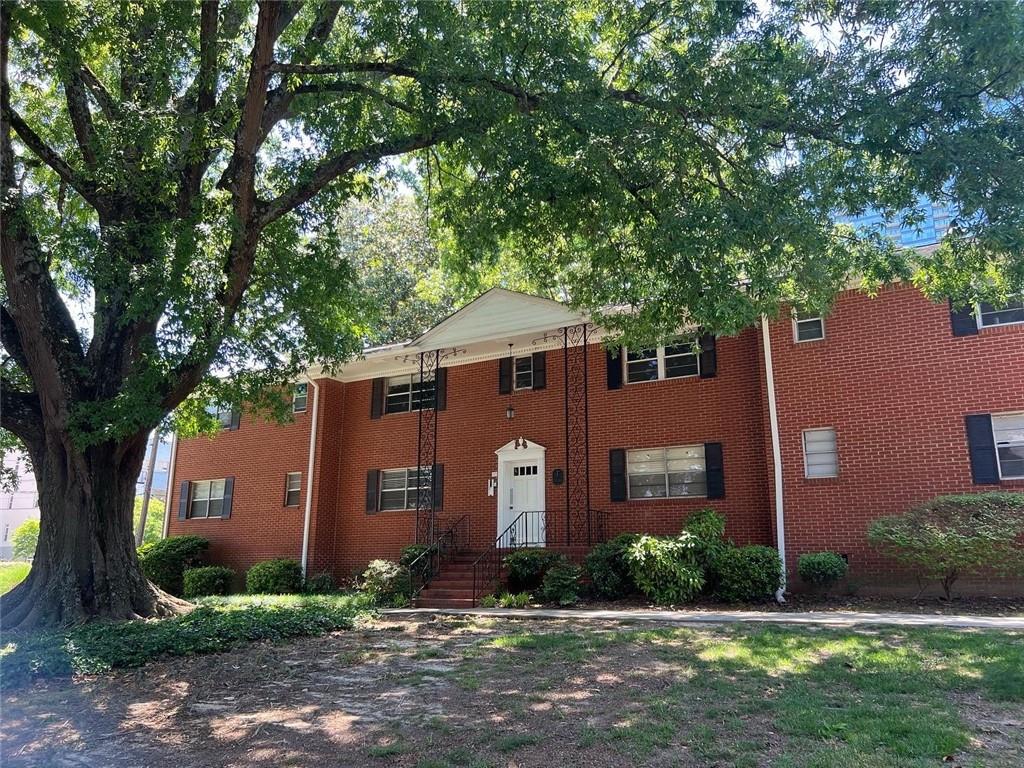 3660 Peachtree Road Northeast, Unit F4 Atlanta, GA 30319 - Photo 1 of 1 a front view of a house with a yard and tree