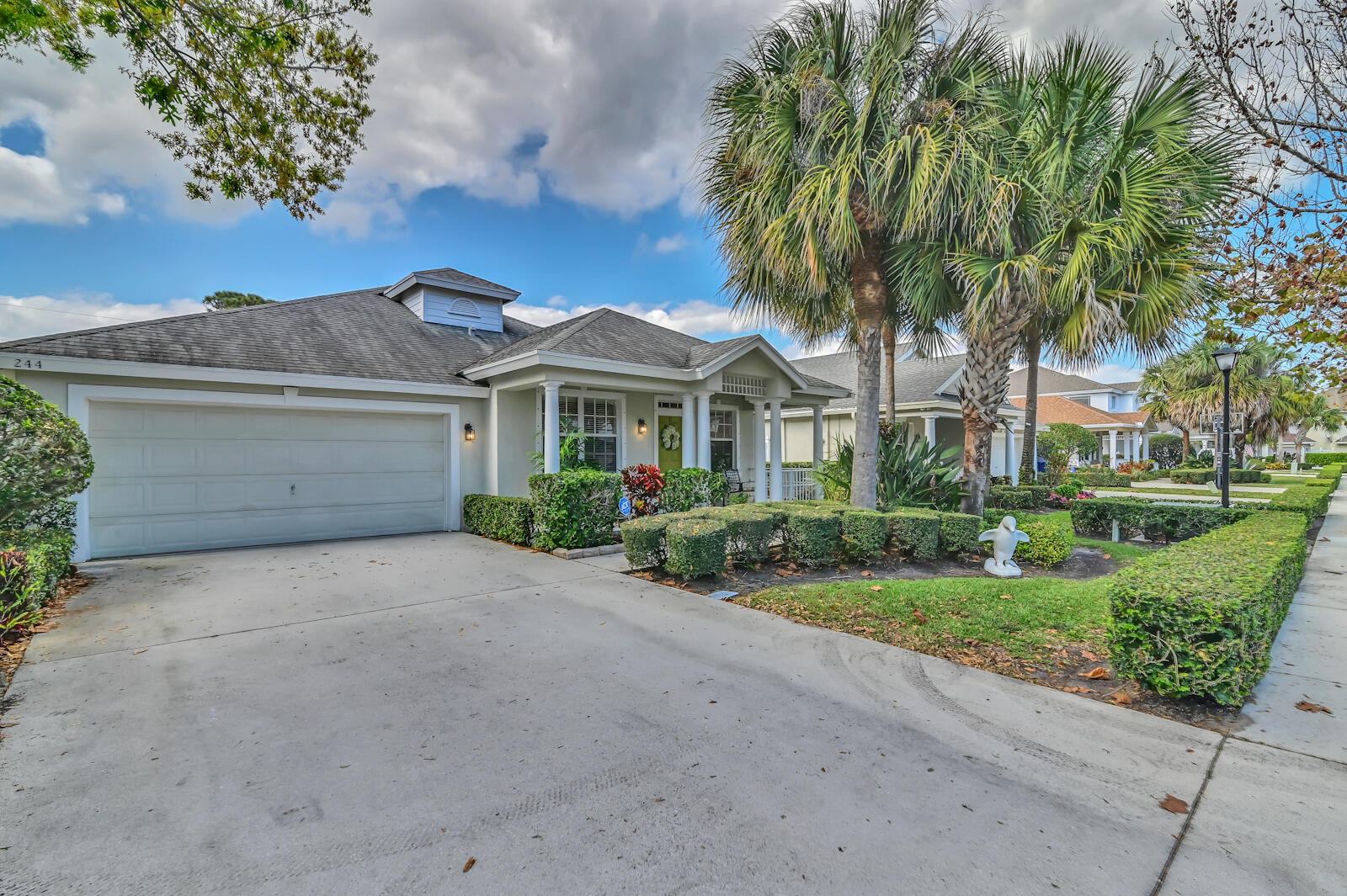 244 Clocktower Drive Jupiter, FL 33458 - Photo 1 of 36 a front view of a house with a garden