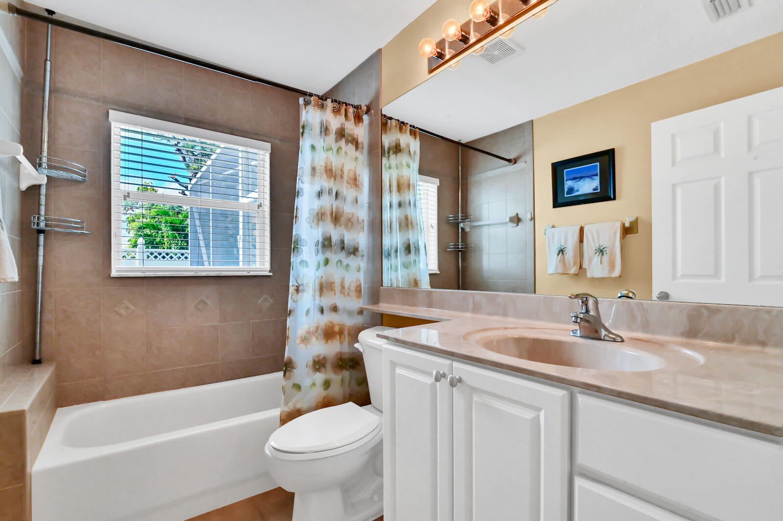 244 Clocktower Drive Jupiter, FL 33458 - Photo 21 of 36 a bathroom with a sink a toilet a mirror a vanity a window and shower
