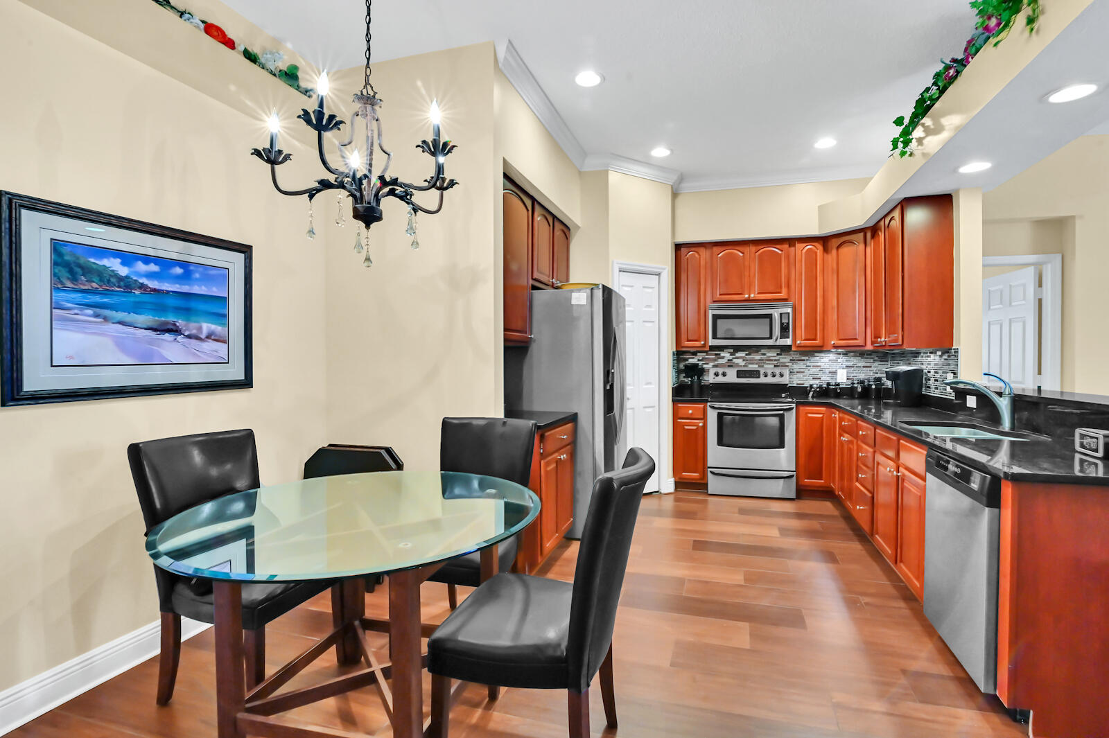 244 Clocktower Drive Jupiter, FL 33458 - Photo 6 of 36 a view of a dining room with furniture a chandelier and wooden floor