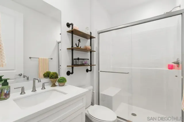 a bathroom with a sink a toilet and shower