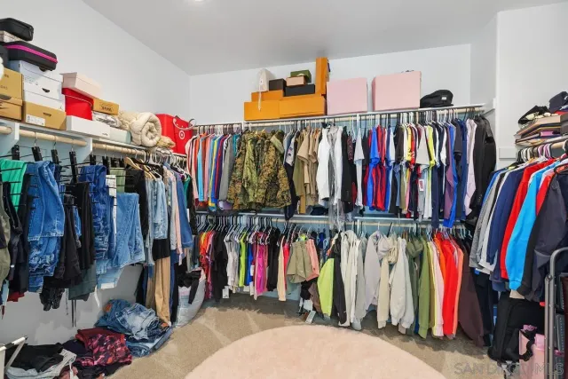 a view of walk in closet with clothes