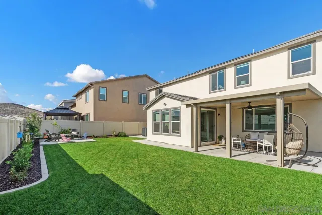 a view of a house with a yard and sitting area