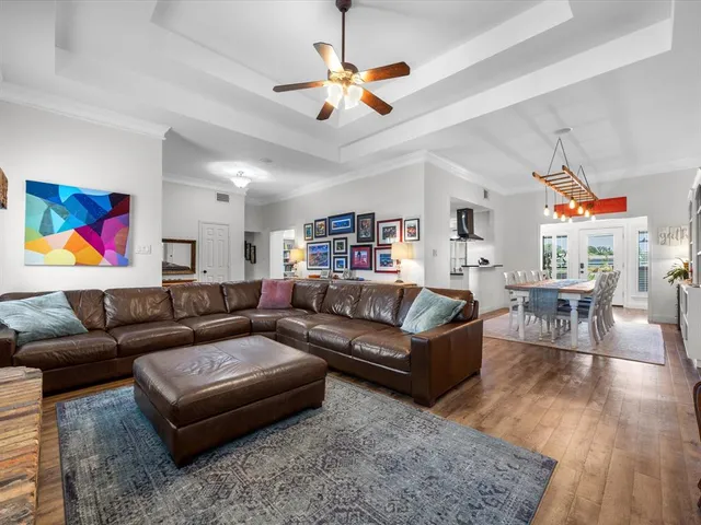 a living room with furniture kitchen view and a chandelier