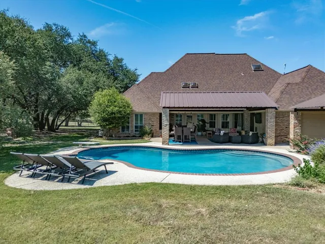 a view of a house with swimming pool and a yard