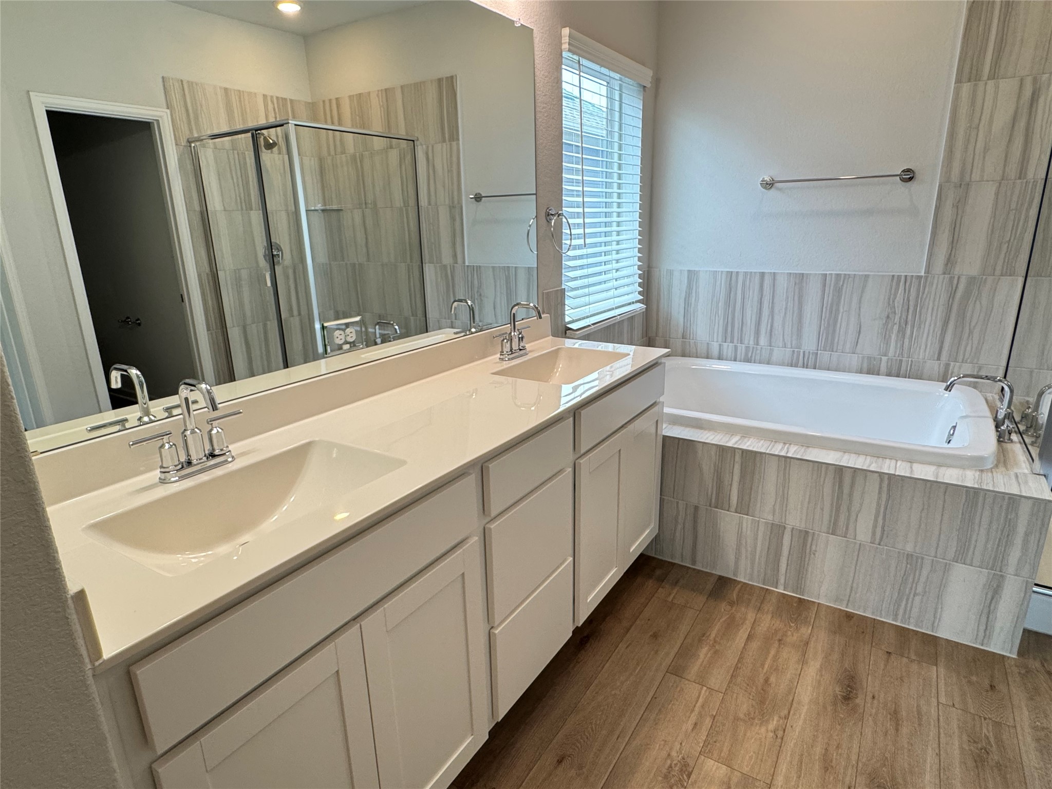 3000 Chisholm Trail Road, Unit 103 Round Rock, TX 78681 - Photo 17 of 32 a bathroom with a double vanity sink a mirror and a bathtub