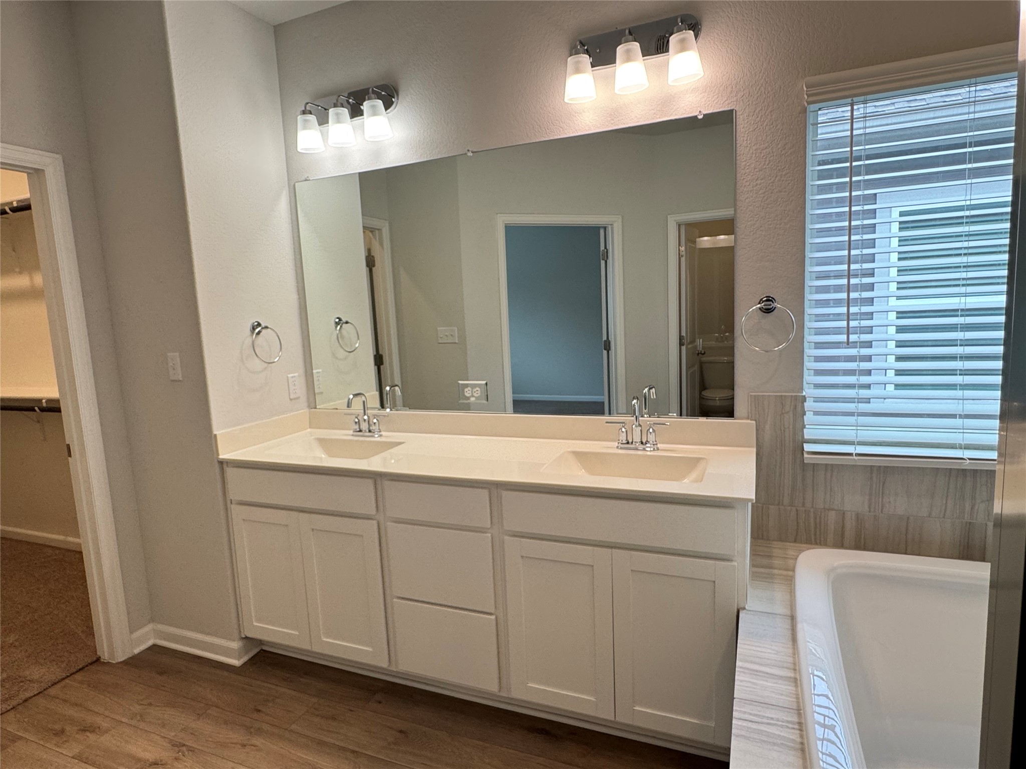 3000 Chisholm Trail Road, Unit 103 Round Rock, TX 78681 - Photo 19 of 32 Bathroom featuring double vanity, a walk in closet, and dark wood-style floors
