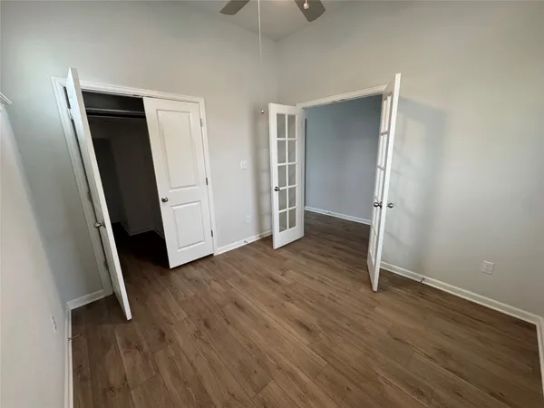 an empty room with wooden floor and closet area