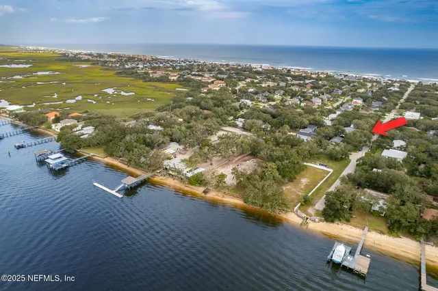 a view of a white house with potted plants
