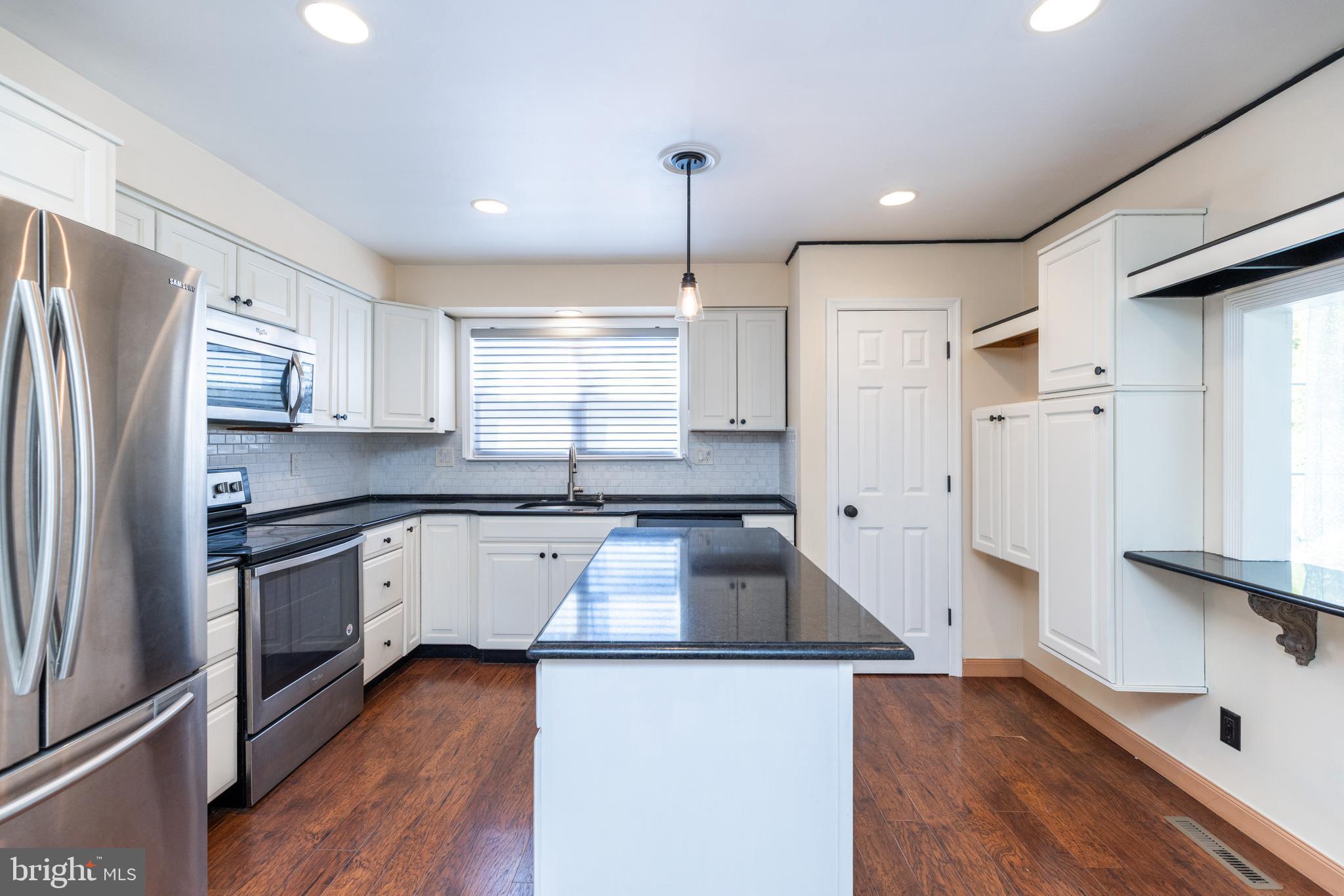 274 Birch Street Newark, DE 19711 - Photo 11 of 41 a kitchen with stainless steel appliances granite countertop a refrigerator a sink dishwasher a stove and white countertops with wooden floor