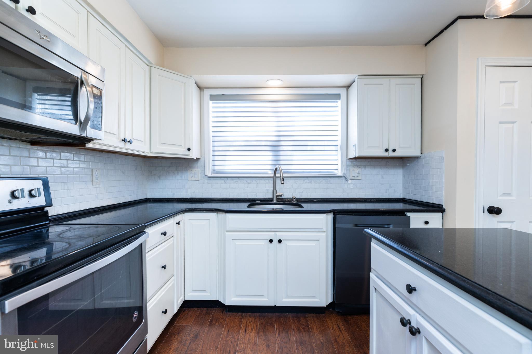 274 Birch Street Newark, DE 19711 - Photo 14 of 41 a kitchen with granite countertop wooden cabinets and a stove