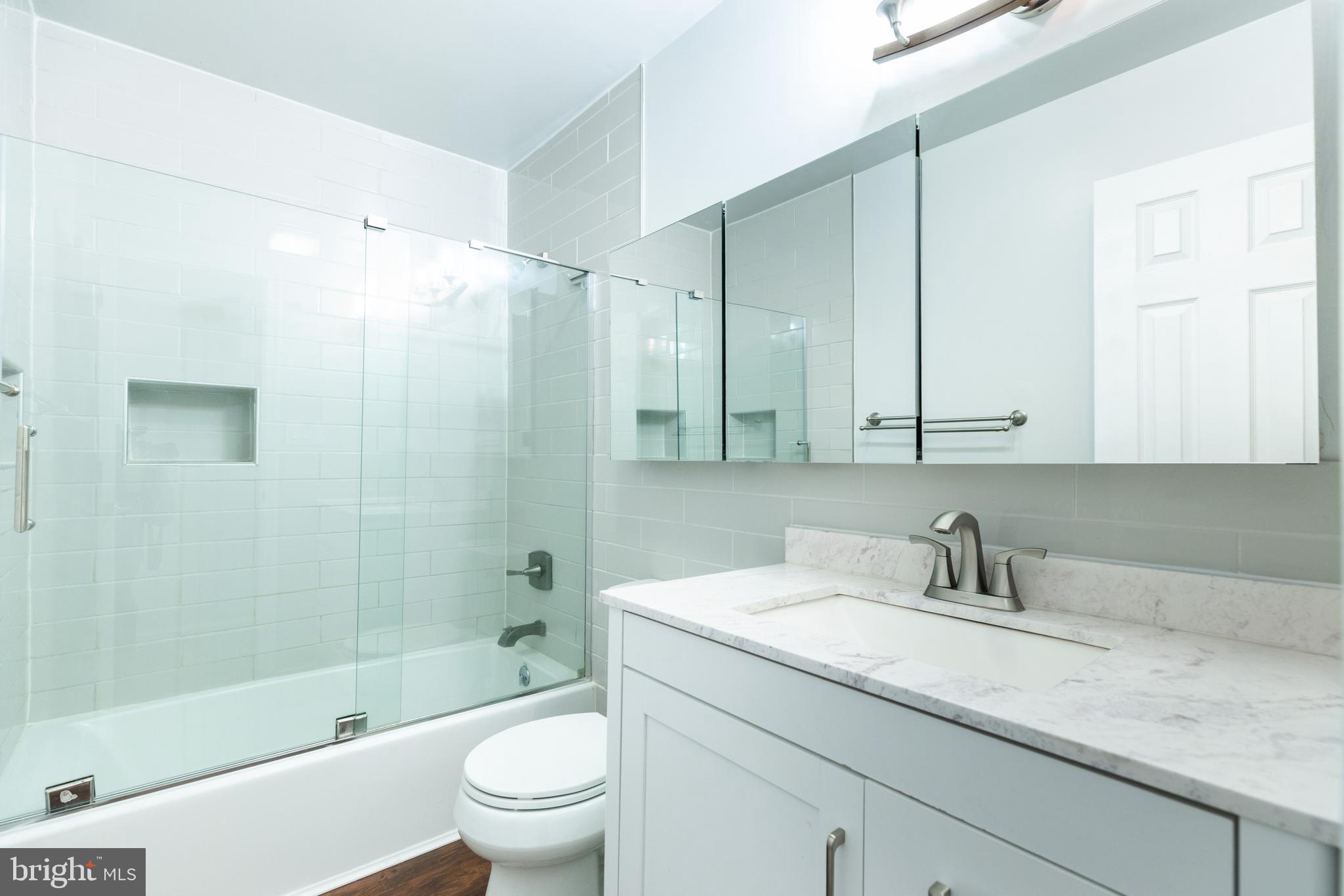 274 Birch Street Newark, DE 19711 - Photo 18 of 41 a bathroom with a granite countertop sink a toilet and shower