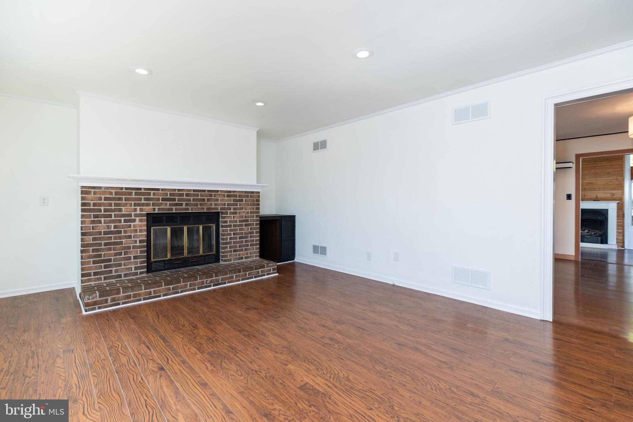 274 Birch Street Newark, DE 19711 - Photo 5 of 41 a view of an empty room with wooden floor fireplace and a window