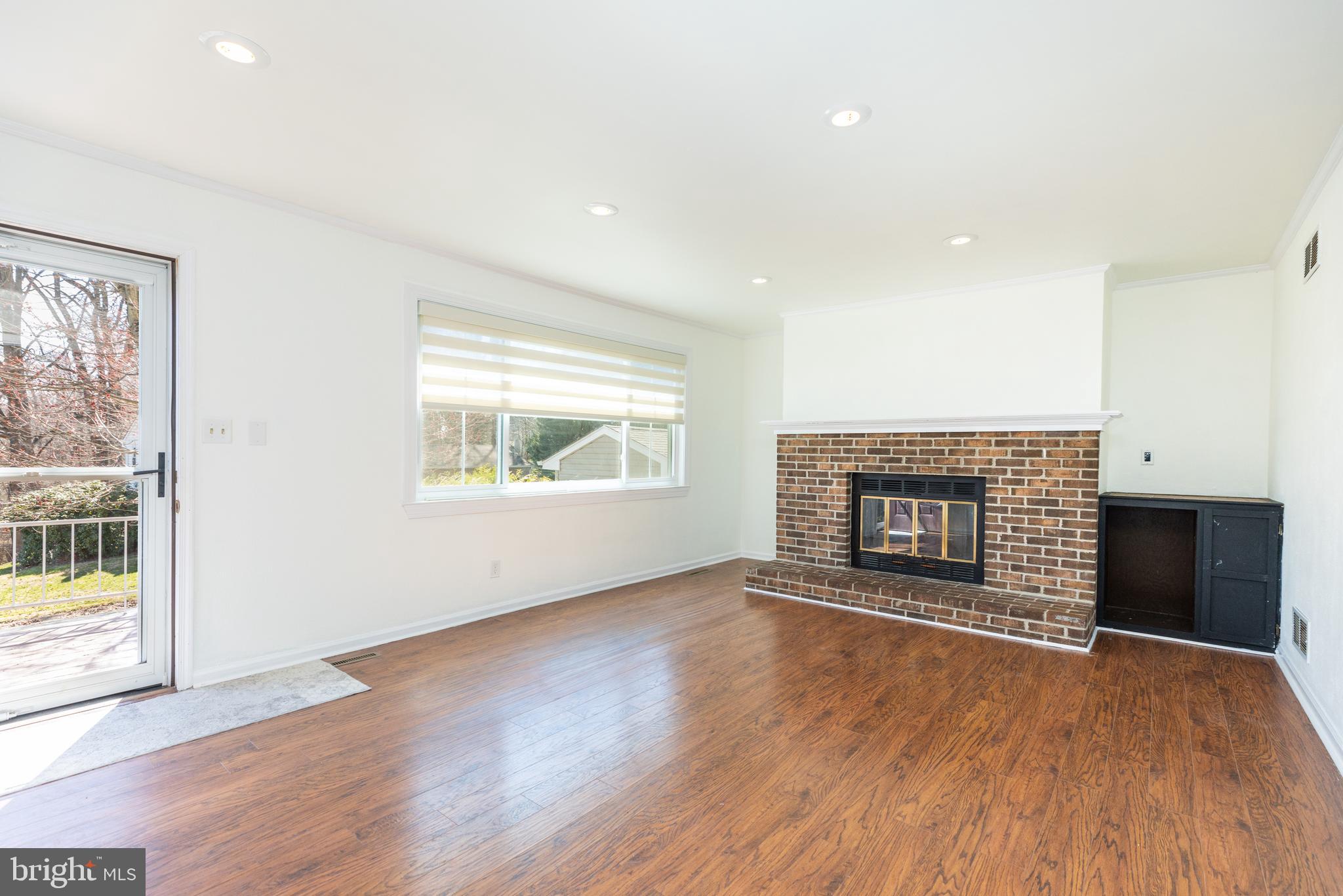 274 Birch Street Newark, DE 19711 - Photo 7 of 41 an empty room with wooden floor fireplace and windows