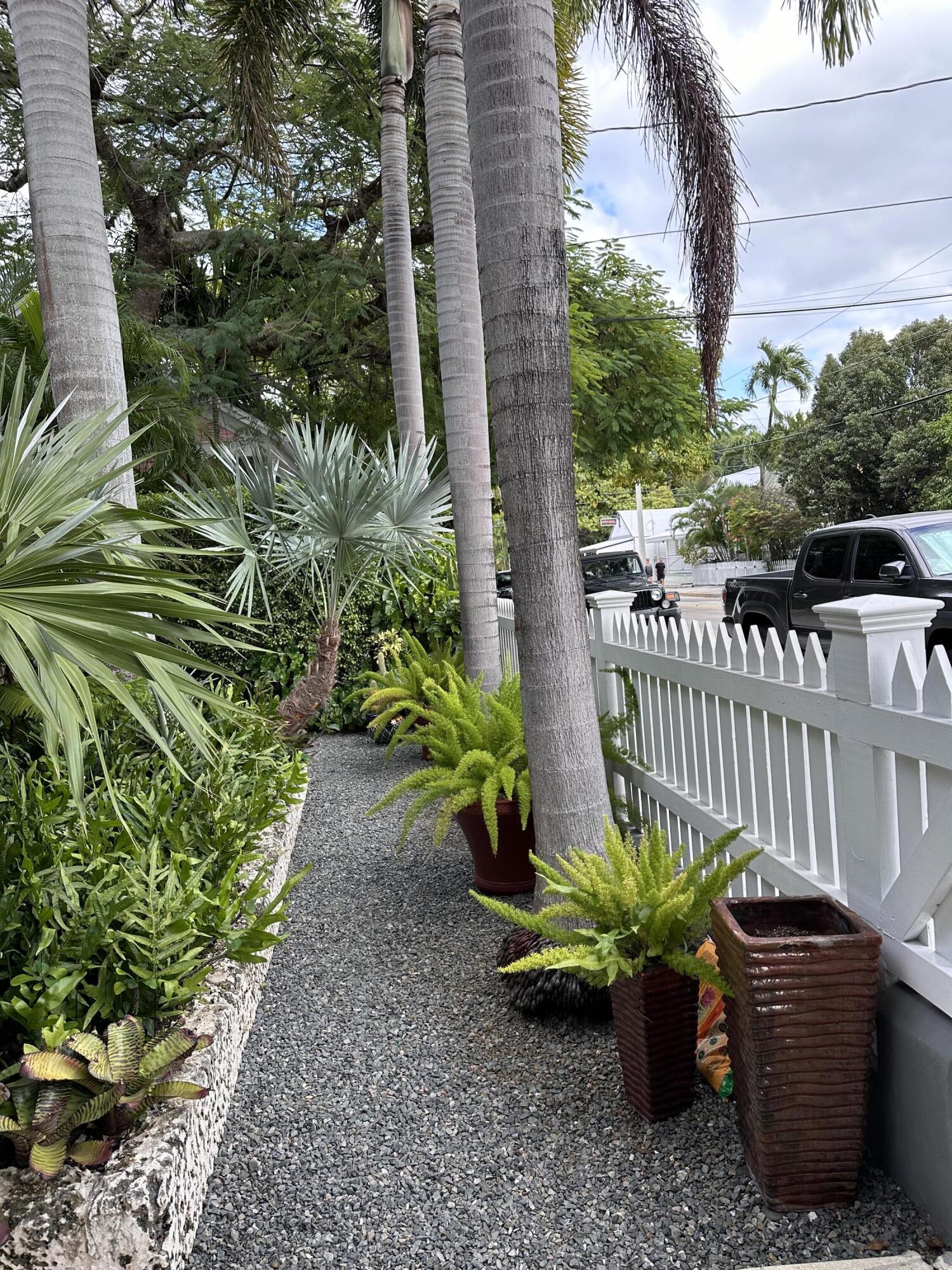 817 Eaton Street, Unit 1 Key West, FL 33040 - Photo 29 of 30 a house with a garden filled with potted plants