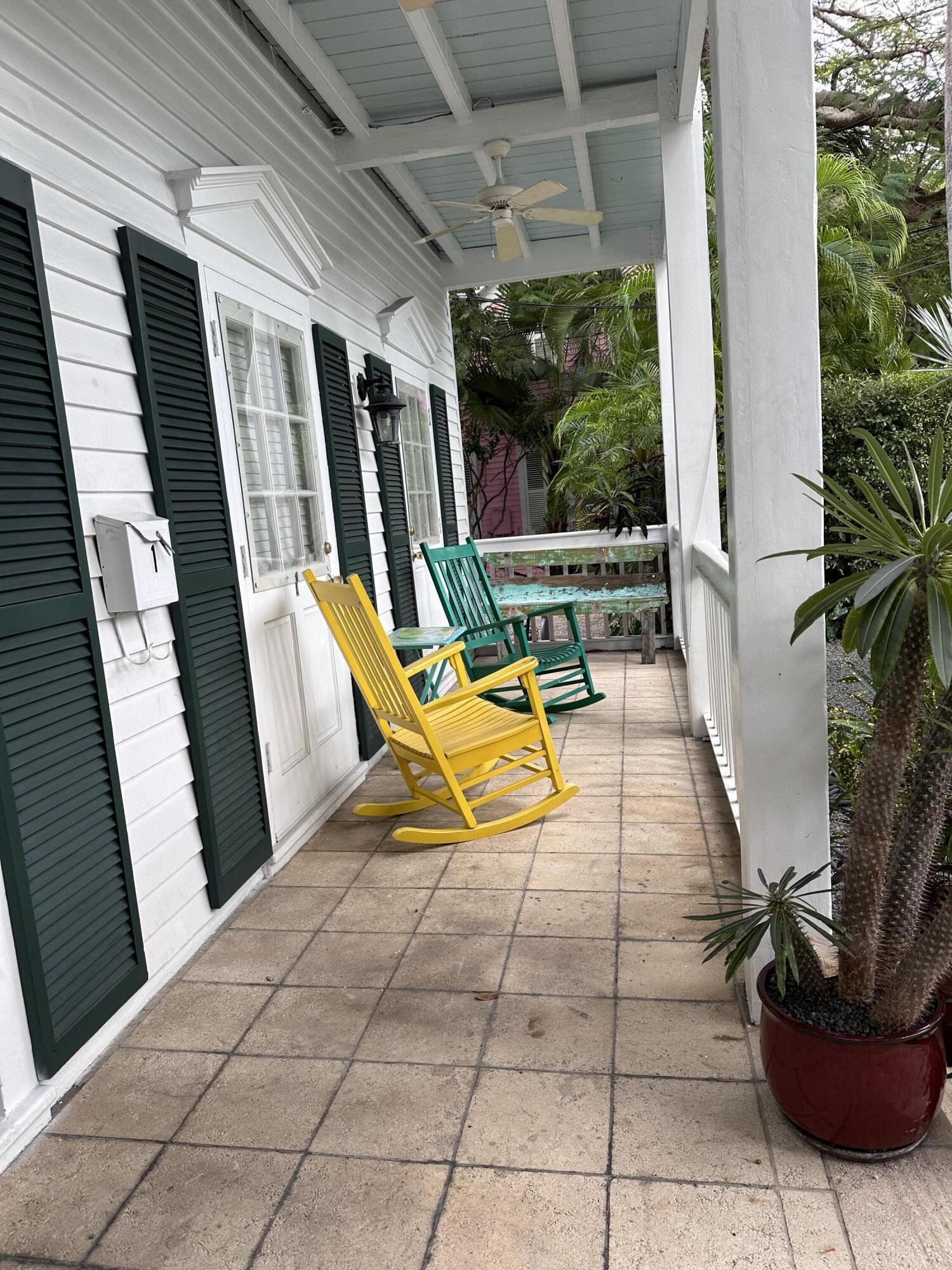 817 Eaton Street, Unit 1 Key West, FL 33040 - Photo 3 of 30 a view of a small backyard with couches potted plants and a floor to ceiling window