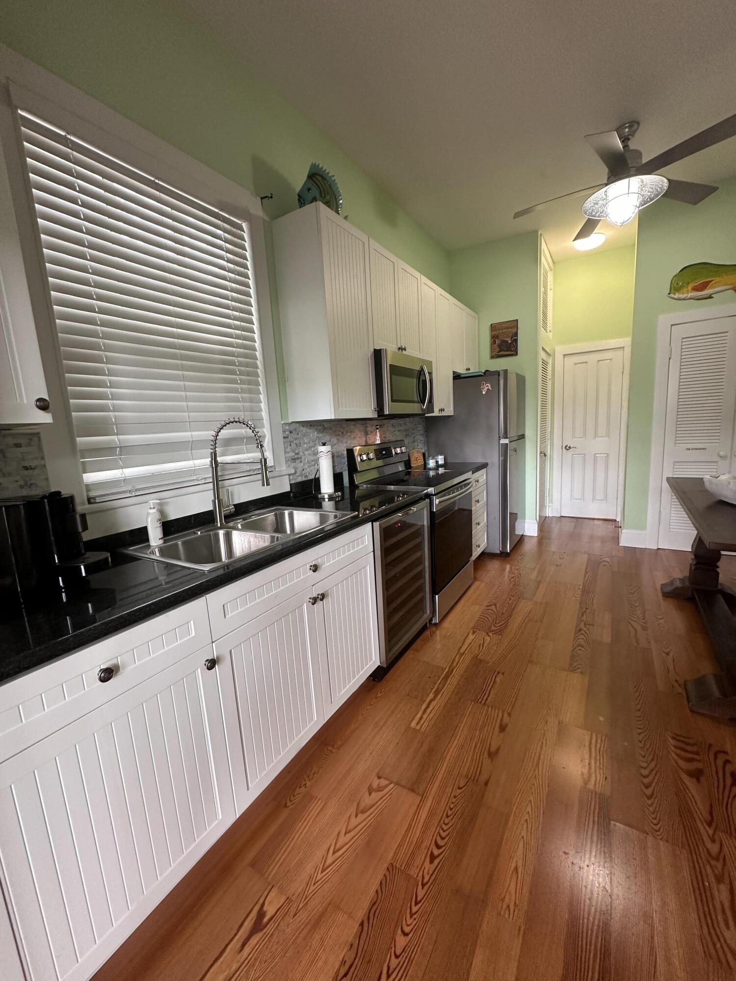 817 Eaton Street, Unit 1 Key West, FL 33040 - Photo 10 of 30 a kitchen with stainless steel appliances a sink a stove and a wooden floors