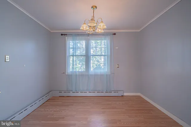 a view of a kitchen with fridge and wooden floor