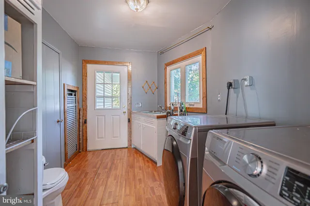 a open kitchen with stainless steel appliances granite countertop a stove a refrigerator a kitchen island a dining table and chairs with wooden floor