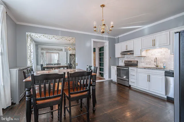 a kitchen with granite countertop white cabinets and stainless steel appliances
