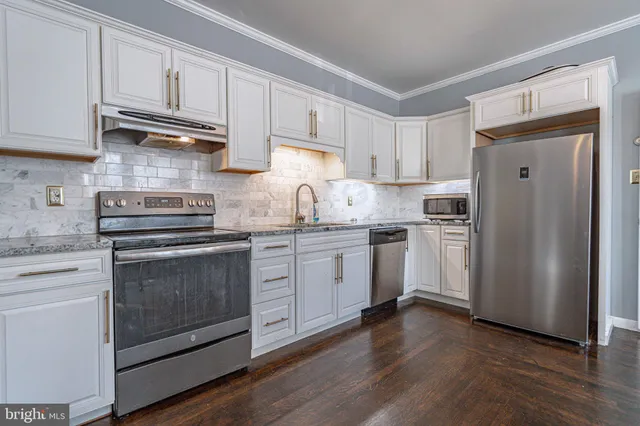 an empty room with a window and a chandelier fan