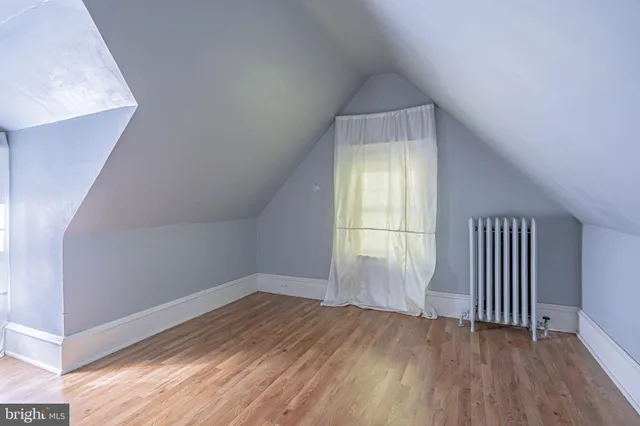 a view of a backyard with table and chairs potted plants and large tree