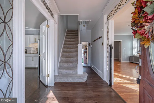 a view of a hallway with wooden floor and staircase