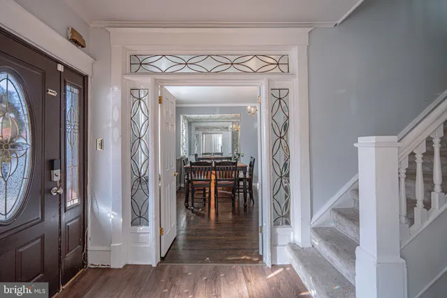 an empty room with wooden floor ceiling fan and windows