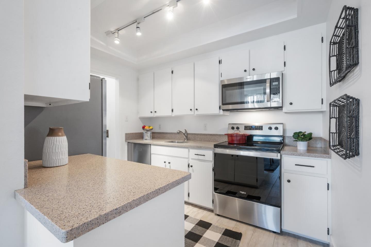 500 Almer Road, Unit 208 Burlingame, CA 94010 - Photo 15 of 30 a kitchen with stainless steel appliances a stove sink microwave and cabinets