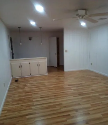 a view of an empty room with wooden floor