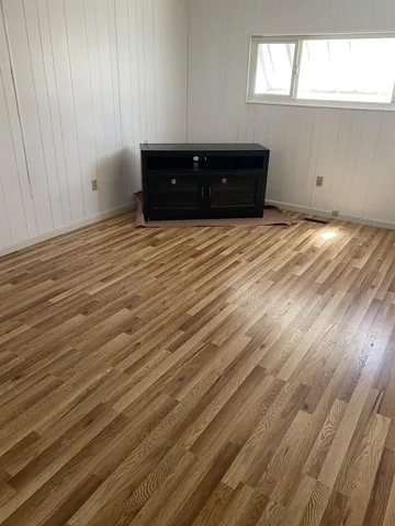 a big room with wooden floor and windows