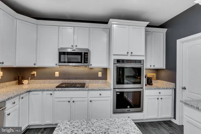 a view of a kitchen counter top space with granite countertop cabinets