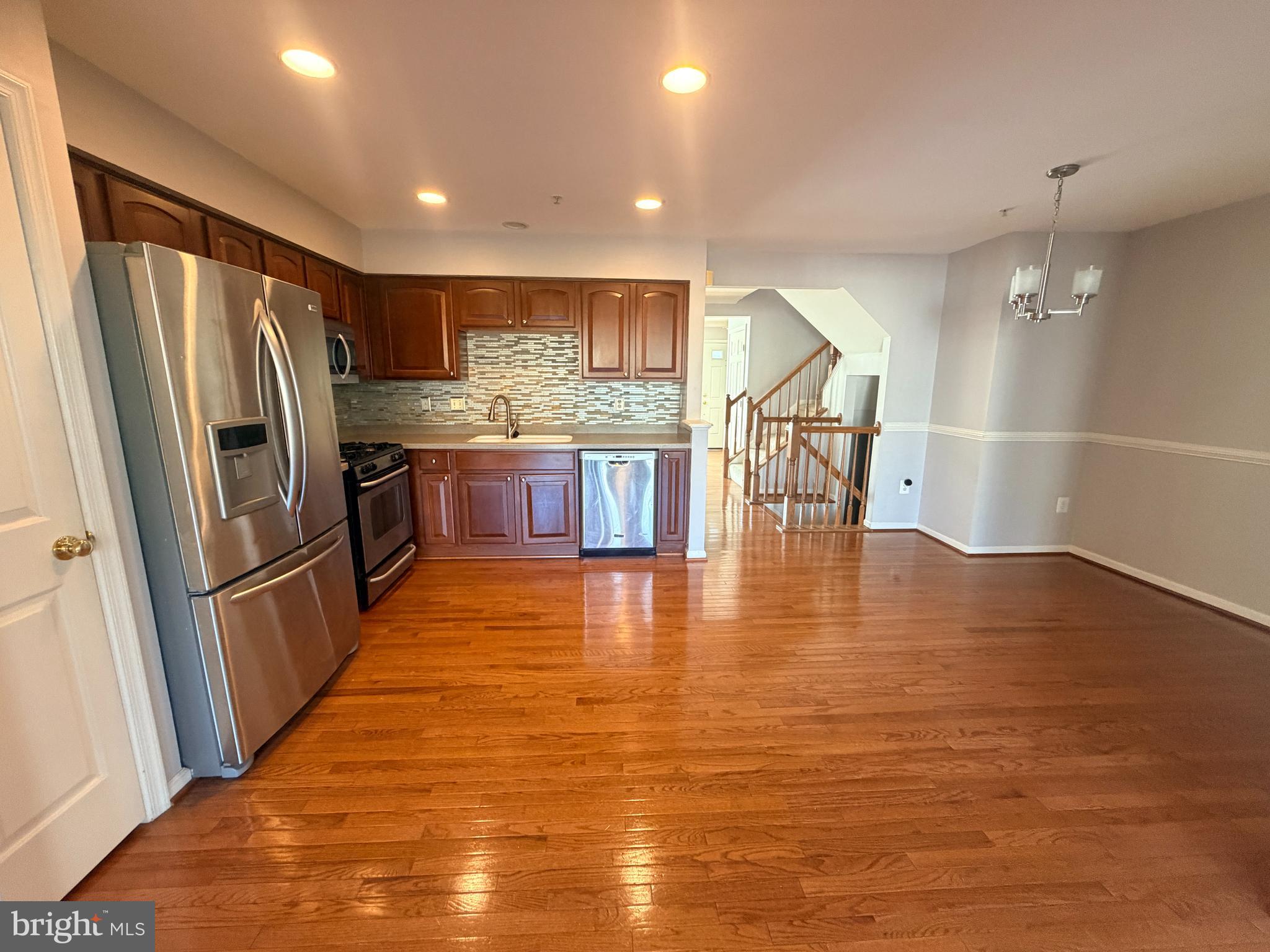 7088 Maiden Point Place, Unit 25 Elkridge, MD 21075 - Photo 11 of 29 a kitchen with stainless steel appliances granite countertop a refrigerator a sink a stove and a wooden floors