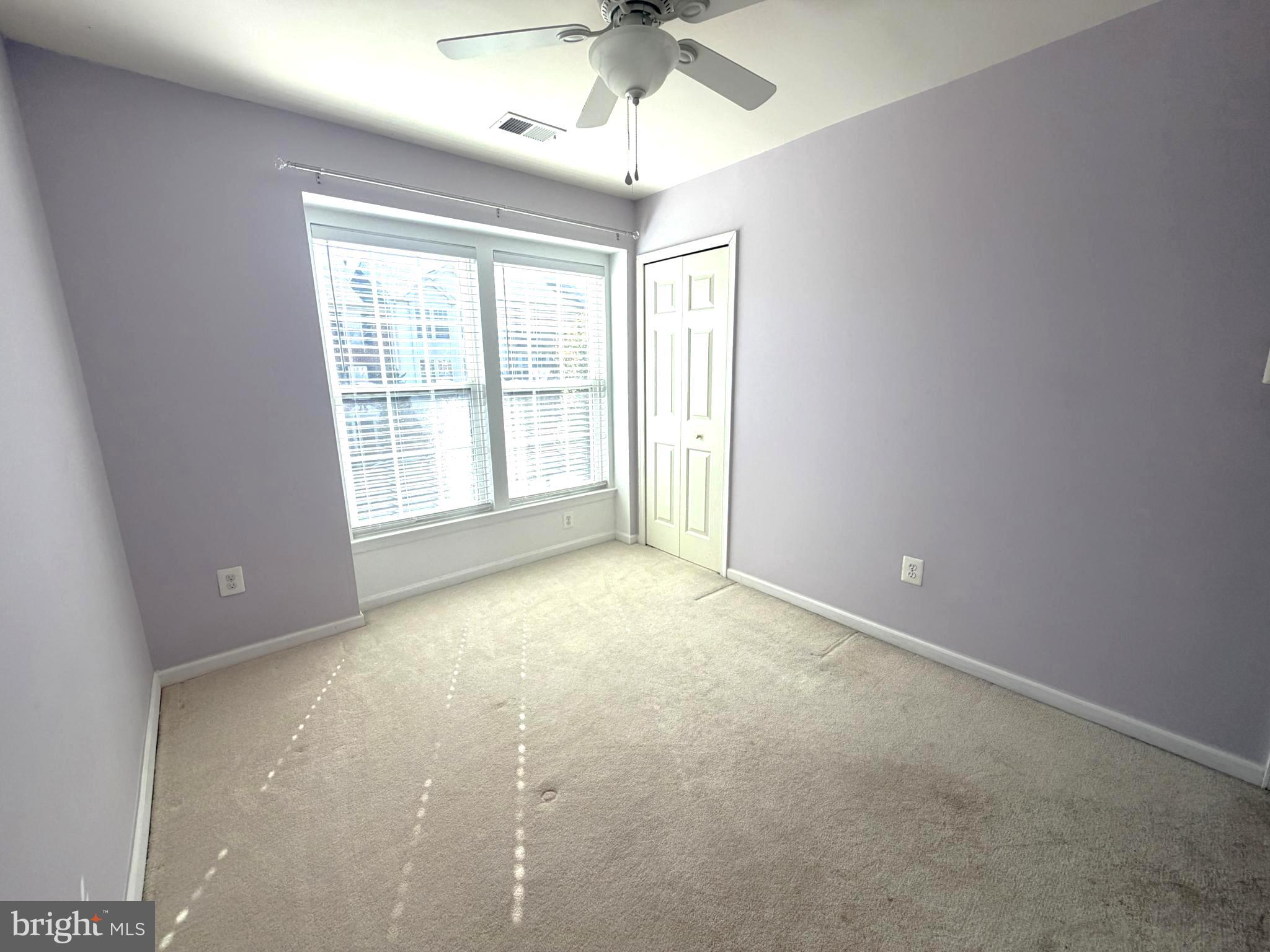 7088 Maiden Point Place, Unit 25 Elkridge, MD 21075 - Photo 16 of 29 an empty room with a chandelier fan and windows