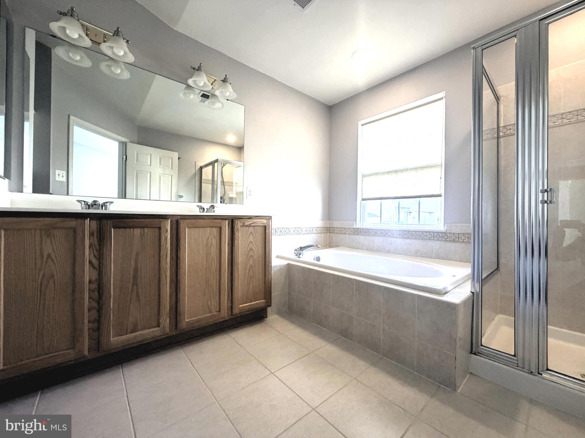 7088 Maiden Point Place, Unit 25 Elkridge, MD 21075 - Photo 23 of 29 a spacious bathroom with a granite countertop tub sink and mirror