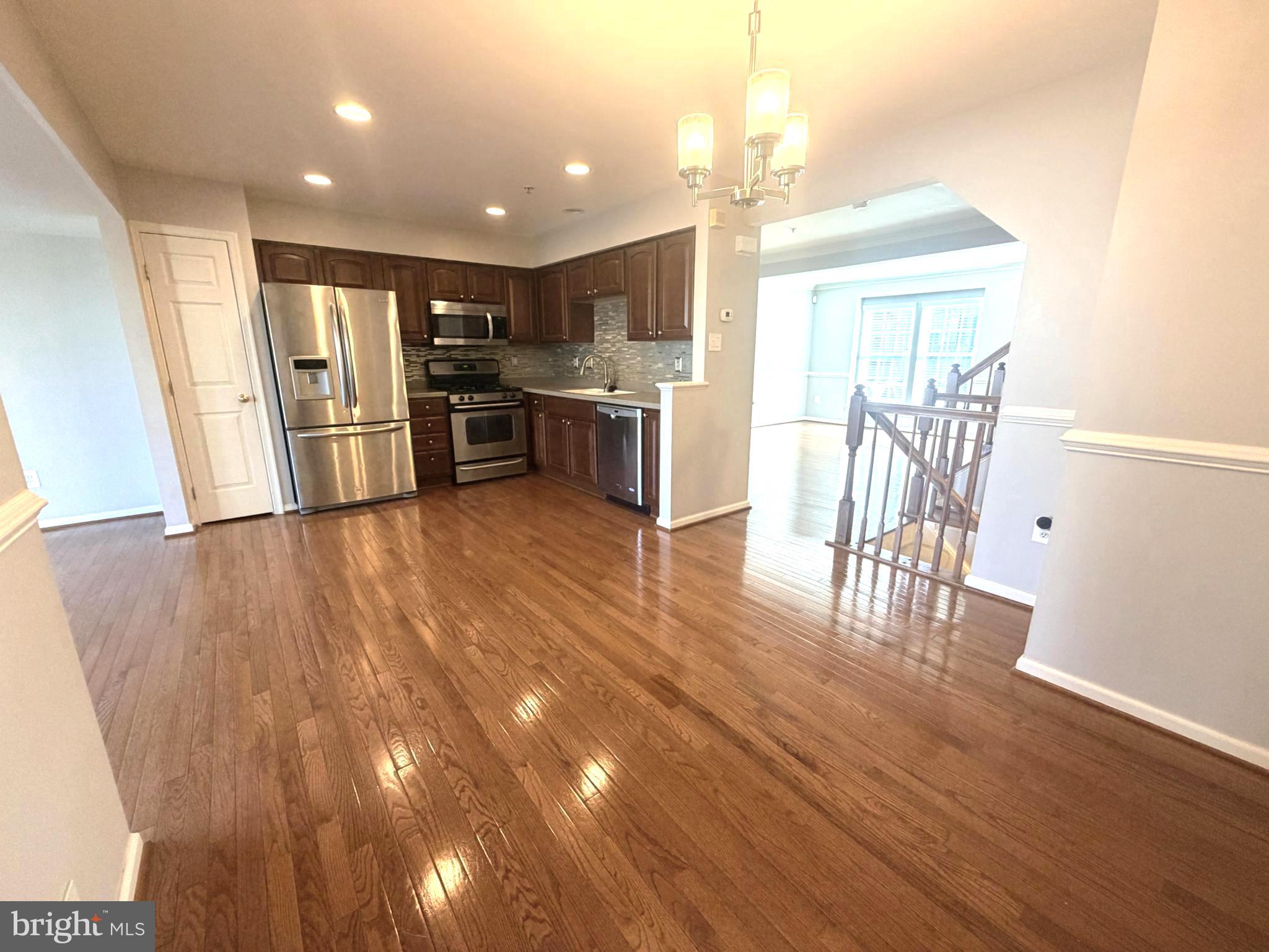 7088 Maiden Point Place, Unit 25 Elkridge, MD 21075 - Photo 10 of 29 a open kitchen with stainless steel appliances wooden floor dining table and chairs