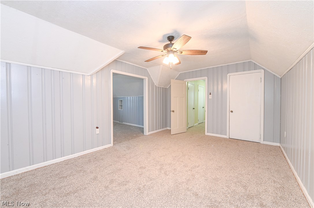 8301 Ackley Road Parma, OH 44129 - Photo 29 of 47 Additional living space featuring light carpet, vaulted ceiling, ceiling fan, and a textured ceiling