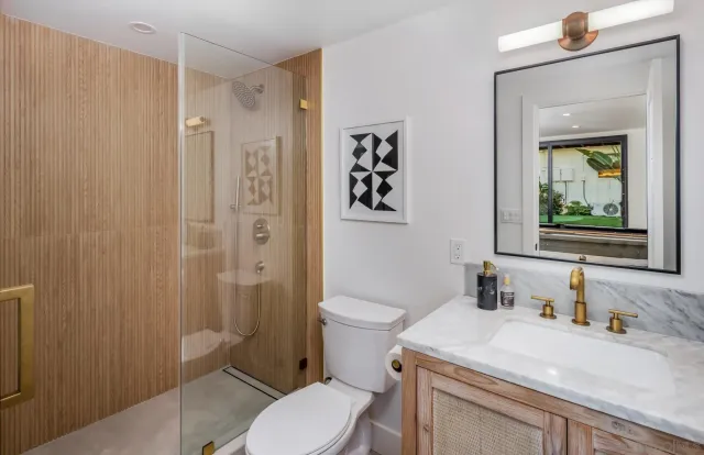 a living room with stainless steel appliances kitchen island granite countertop a sink a refrigerator and a couch